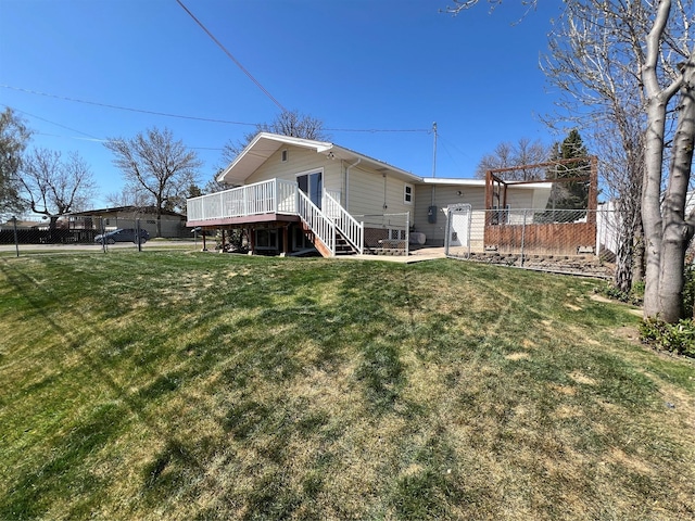 back of house featuring a yard, fence private yard, a deck, and stairway
