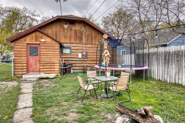 308 S 4th St, Hamilton, MT 59840 - rear view of property with fence, a trampoline, log exterior, and a yard