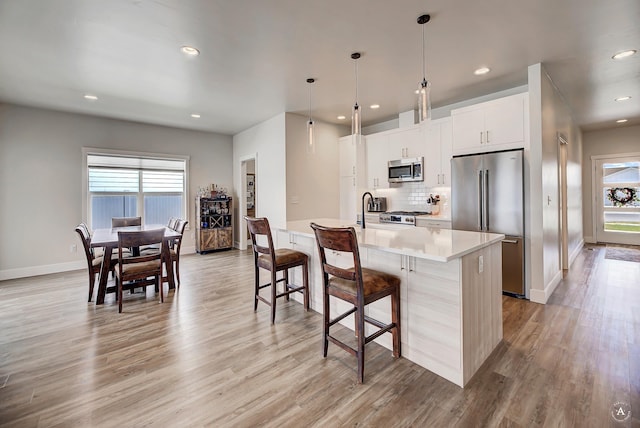 2800 Ashley Ave, East Helena, MT 59635 - kitchen featuring a breakfast bar area, stainless steel appliances, baseboards, and plenty of natural light