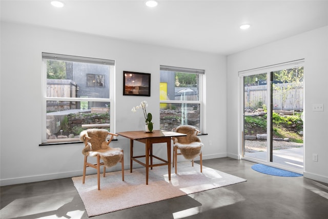 interior space with baseboards, recessed lighting, and finished concrete flooring
