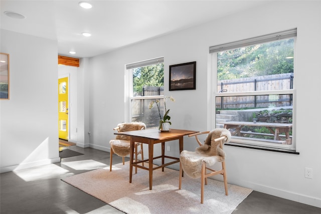 dining space featuring baseboards, concrete flooring, and recessed lighting