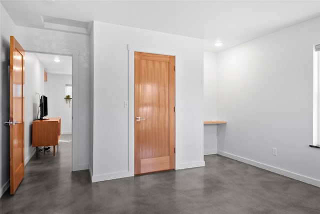 bedroom with recessed lighting, baseboards, and finished concrete flooring