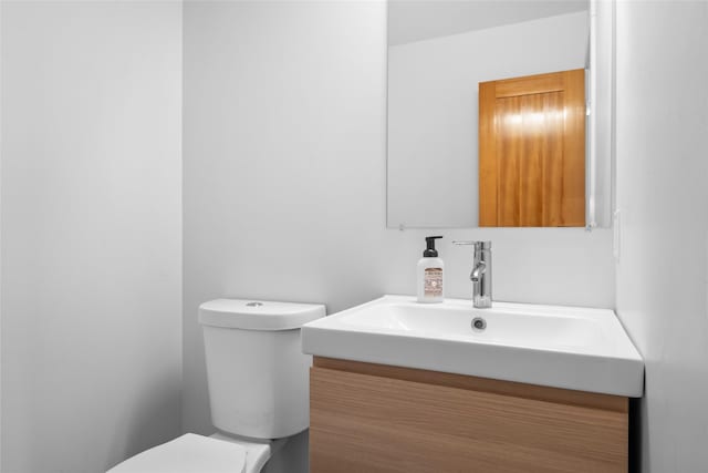 half bathroom featuring vanity and toilet