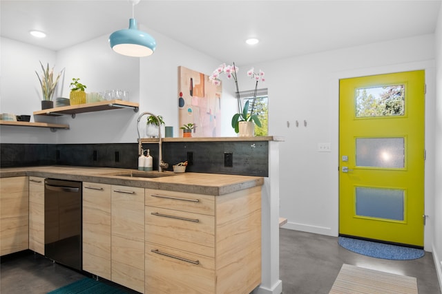kitchen with stainless steel dishwasher, light brown cabinetry, modern cabinets, a sink, and concrete floors