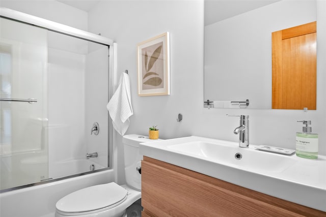 full bathroom featuring toilet, combined bath / shower with glass door, and vanity