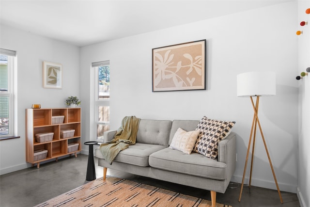 living room with baseboards and concrete flooring