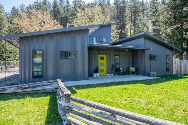 rear view of property with fence and a yard