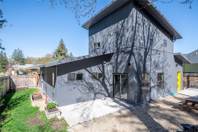 back of property featuring a yard, fence, a garden, and a patio area