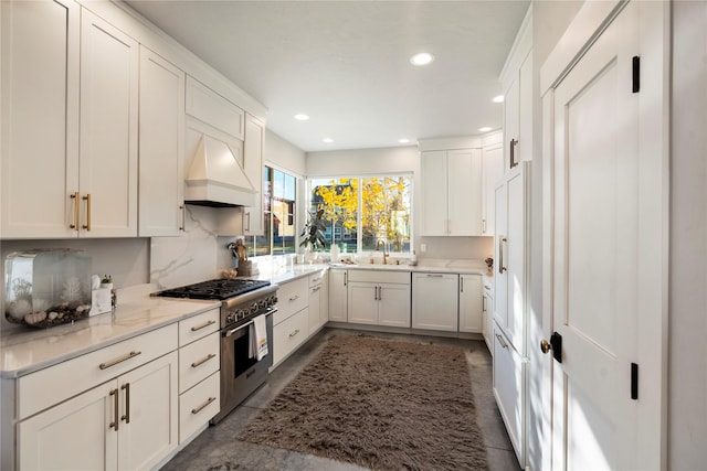 736 Cottonwood Ct, Whitefish, MT 59937 - kitchen with high end stainless steel range, white cabinetry, dishwasher, concrete floors, and recessed lighting