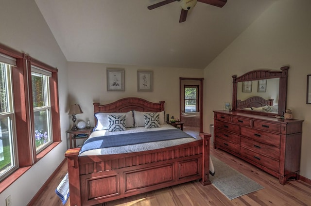 bedroom with light wood-style flooring, vaulted ceiling, and multiple windows