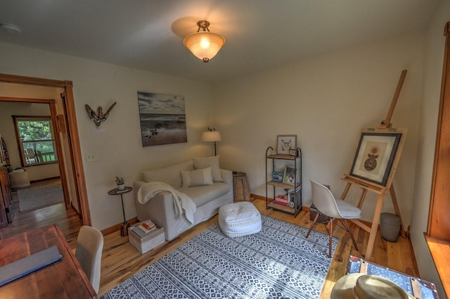 living area with baseboards and wood finished floors