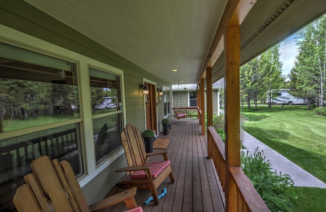 wooden deck featuring a yard and covered porch