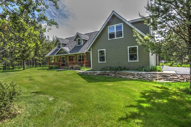 back of property with a lawn and covered porch