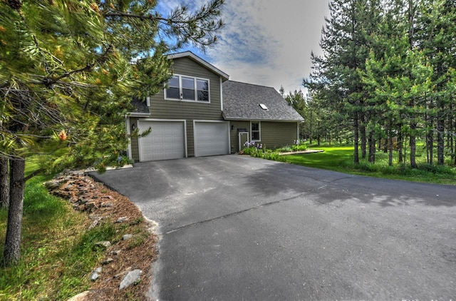 view of front of property with an attached garage, a shingled roof, and aphalt driveway