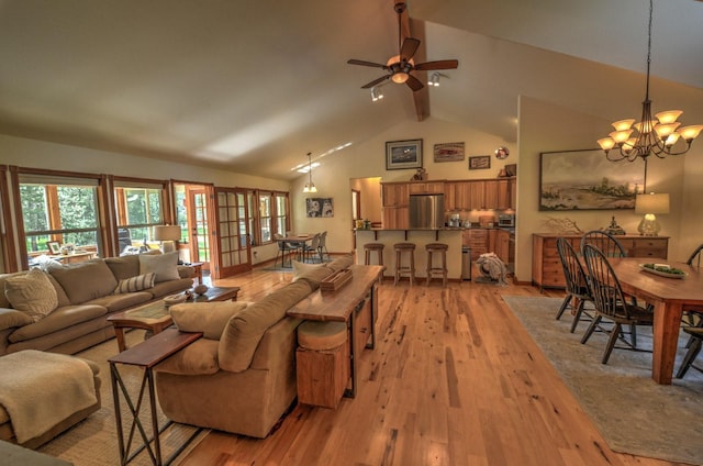 living room with beamed ceiling, plenty of natural light, and light wood-style flooring