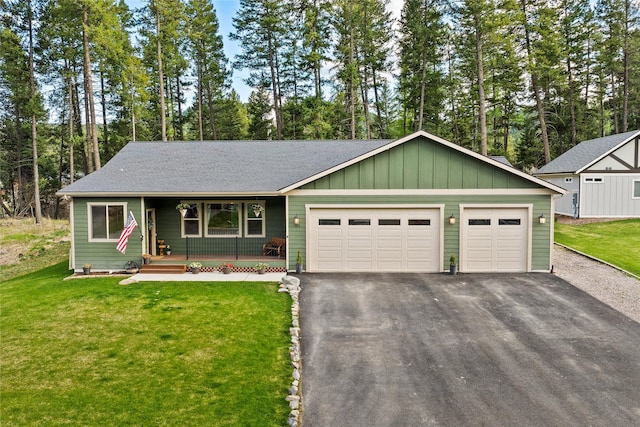 view of front of property featuring a garage, a porch, a front lawn, and aphalt driveway