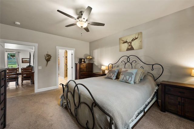bedroom featuring a ceiling fan, baseboards, ensuite bathroom, and carpet