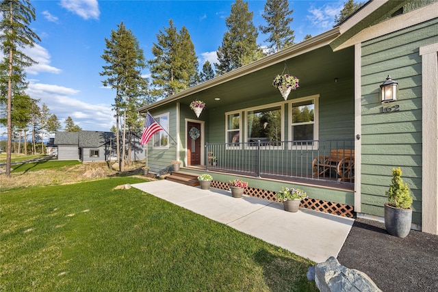 entrance to property with a porch and a yard
