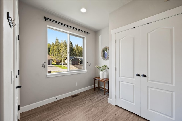 interior space with recessed lighting, baseboards, light wood finished floors, and visible vents