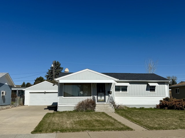 view of front facade featuring a detached garage, an outdoor structure, and a front lawn