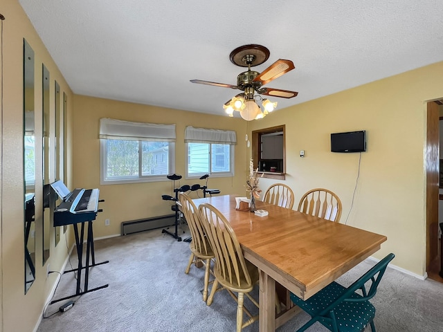 dining space with a textured ceiling, ceiling fan, light colored carpet, and baseboard heating