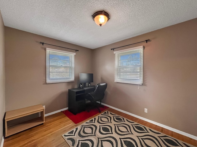 office space with baseboards, a textured ceiling, and wood finished floors