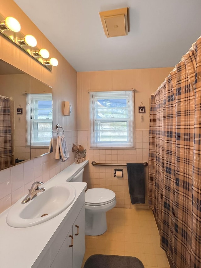 full bath with tile walls, plenty of natural light, toilet, and tile patterned flooring