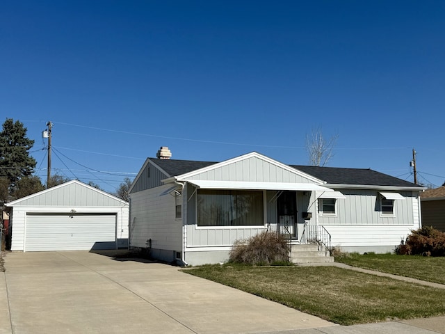 view of front of home with an outdoor structure, a garage, a front lawn, roof with shingles, and board and batten siding