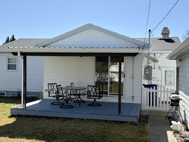 rear view of house featuring roof with shingles and a deck