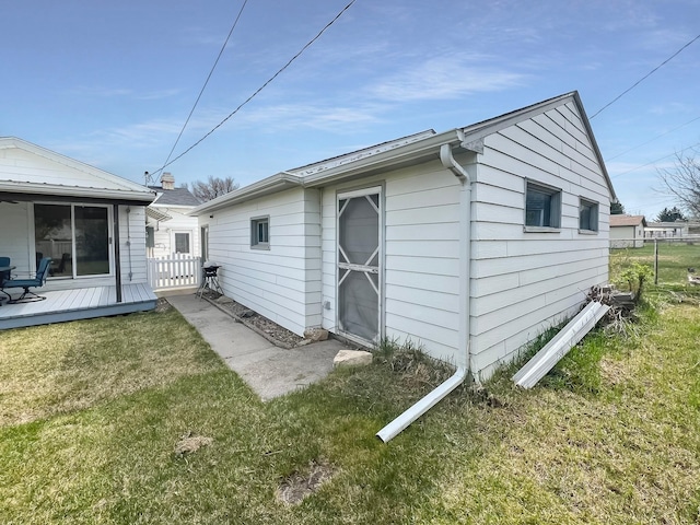 exterior space featuring fence, a wooden deck, and a yard