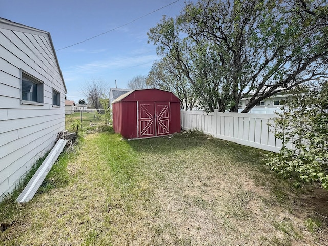 view of yard with an outdoor structure, fence, and a storage unit
