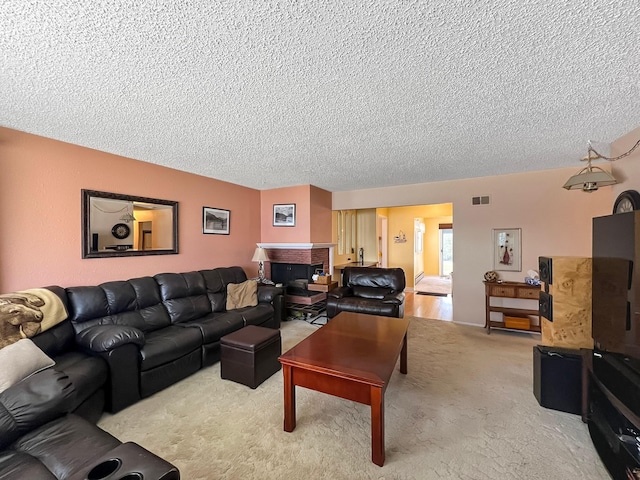 living area with carpet, a textured ceiling, and visible vents