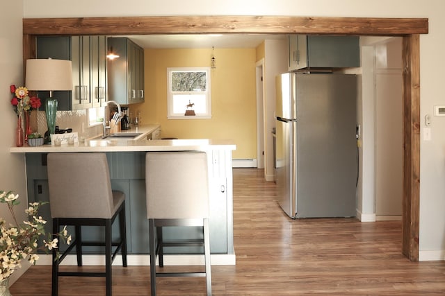 2060 Schilling St, Missoula, MT 59801 - kitchen featuring a sink, light countertops, freestanding refrigerator, a baseboard heating unit, and light wood-style flooring