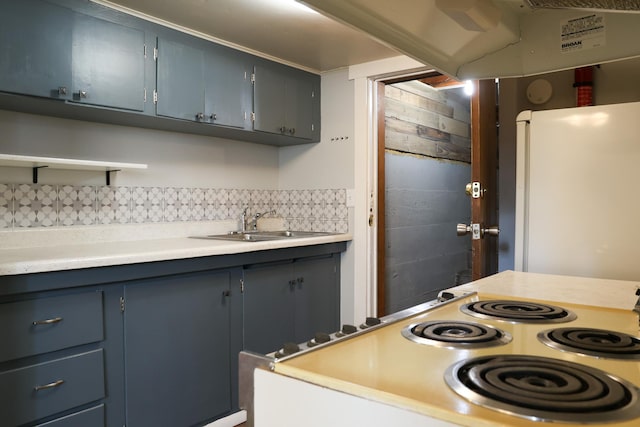 2060 Schilling St, Missoula, MT 59801 - kitchen with freestanding refrigerator, electric range, light countertops, blue cabinets, and backsplash
