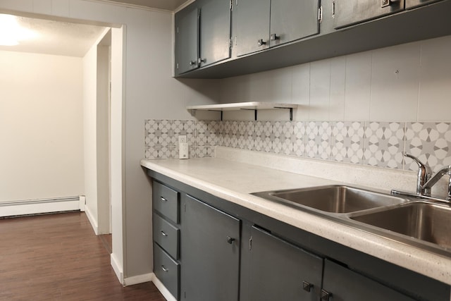 2060 Schilling St, Missoula, MT 59801 - kitchen with dark wood-type flooring, a baseboard radiator, backsplash, and light countertops
