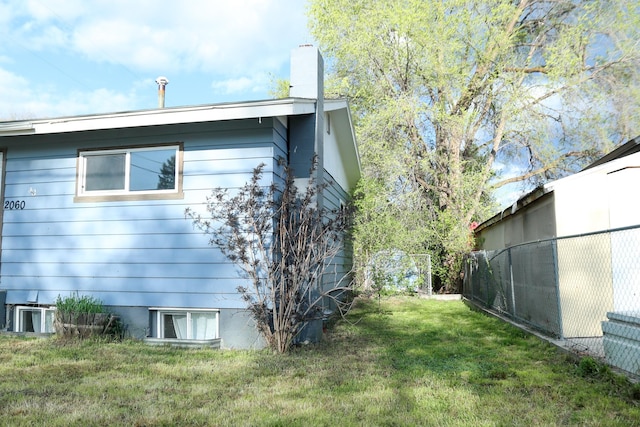 2060 Schilling St, Missoula, MT 59801 - view of side of home with a lawn, fence, and a chimney
