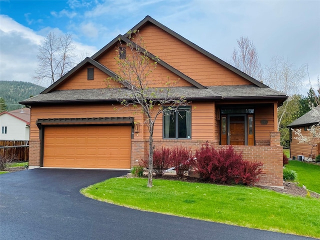 7 Brookside, Missoula, MT 59802 - view of front of house with a front lawn, aphalt driveway, fence, brick siding, and an attached garage