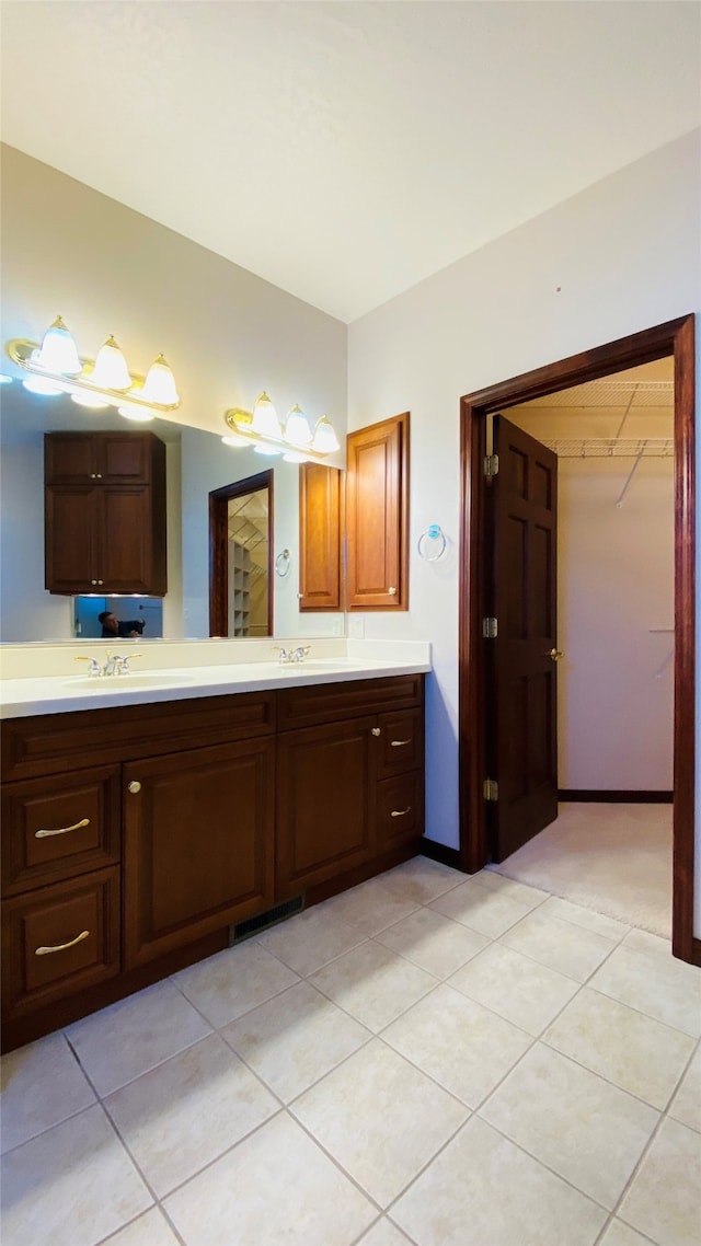 7 Brookside, Missoula, MT 59802 - bathroom with double vanity, a walk in closet, visible vents, a sink, and tile patterned floors