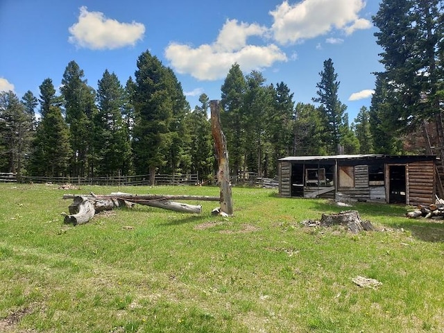 513 Spruce Gulch Rd, Helmville, MT 59843 - view of yard with an exterior structure, an outdoor structure, and a view of trees