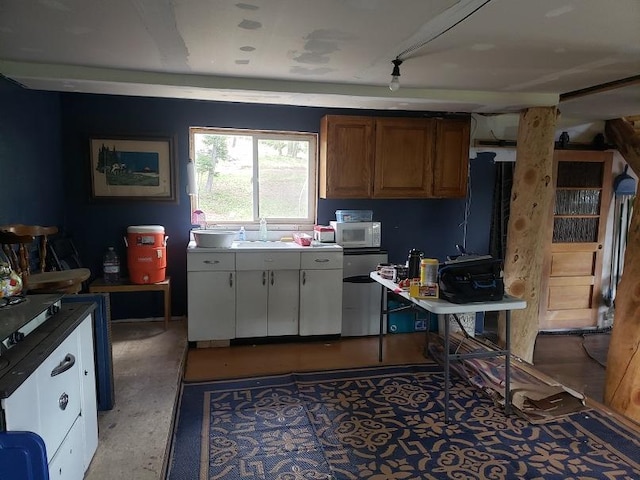 513 Spruce Gulch Rd, Helmville, MT 59843 - kitchen with a sink, white microwave, and brown cabinets