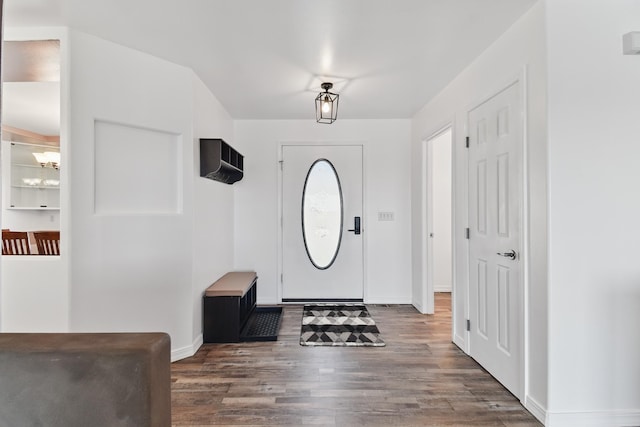 entrance foyer with an inviting chandelier, baseboards, and wood finished floors