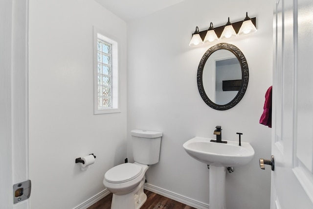 bathroom with toilet, baseboards, and wood finished floors