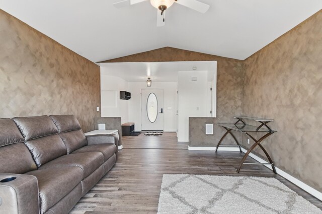 living area featuring baseboards, ceiling fan, vaulted ceiling, and wood finished floors