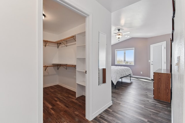 interior space with a ceiling fan, lofted ceiling, and dark wood-style floors