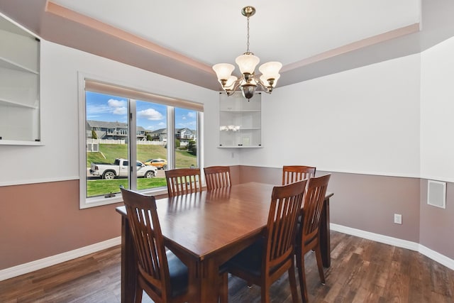 dining space with an inviting chandelier, baseboards, and wood finished floors