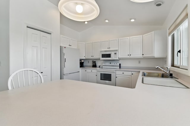 kitchen with a sink, white cabinets, vaulted ceiling, and white appliances