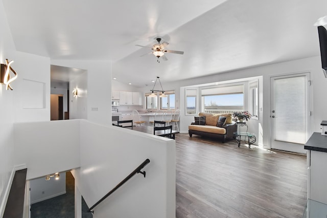 interior space with baseboards, ceiling fan, and wood finished floors