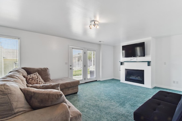 living room with carpet flooring, baseboards, and a glass covered fireplace