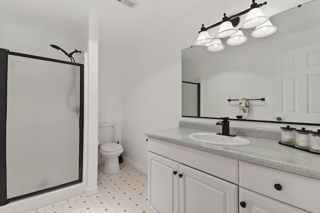 bathroom featuring a stall shower, vanity, tile patterned floors, baseboards, and toilet