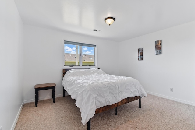 bedroom with baseboards, light carpet, and visible vents